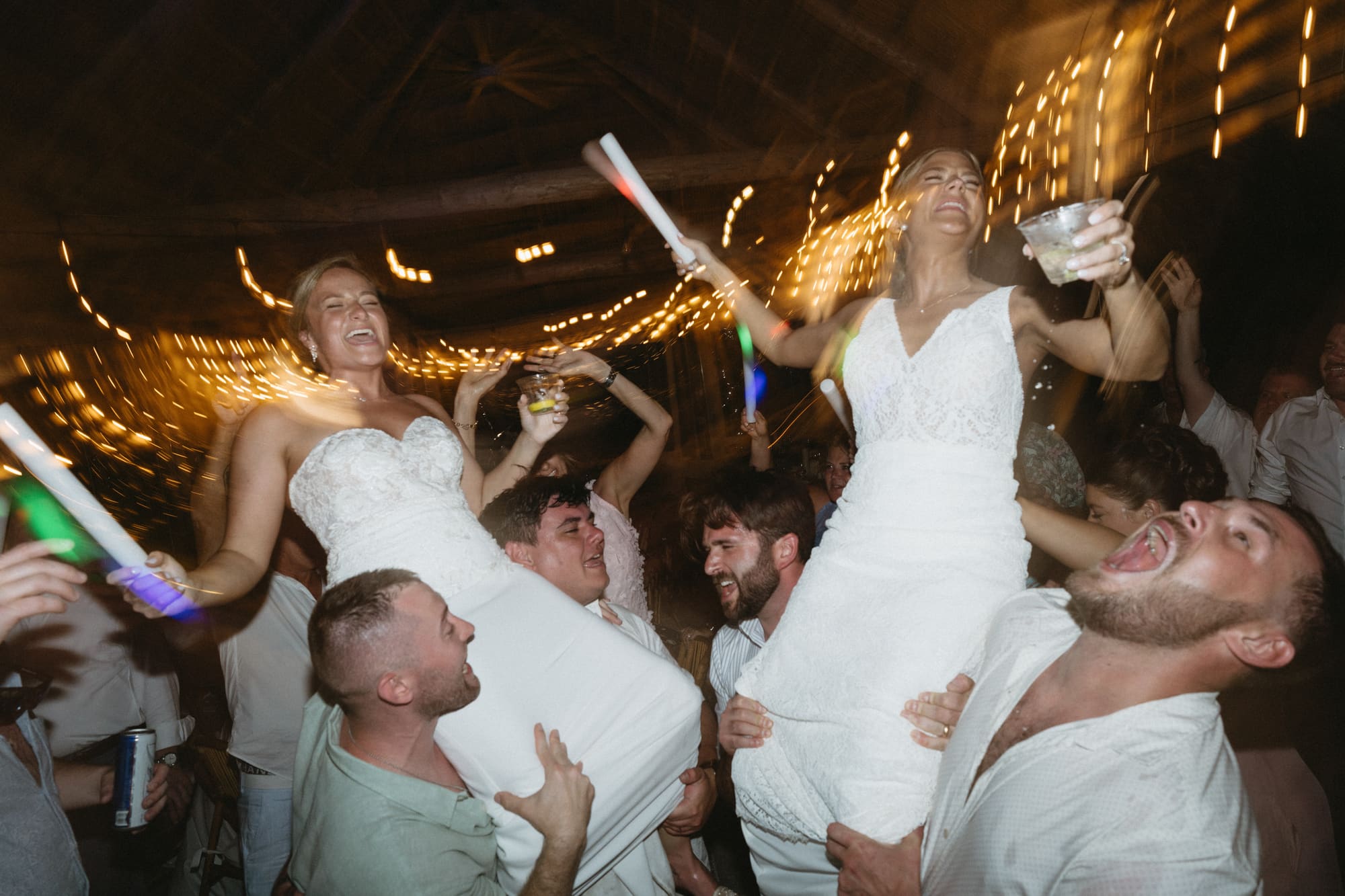 Brides celebrating with sparklers and glow sticks on the dance floor